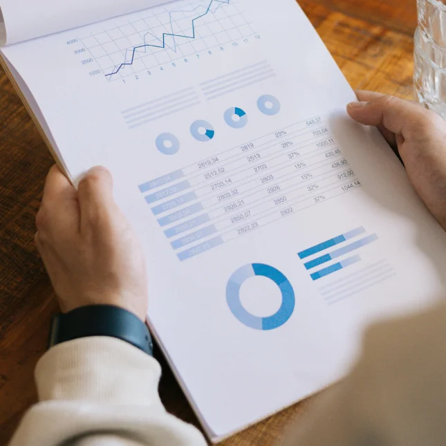 Man holding a report with charts and graphs.